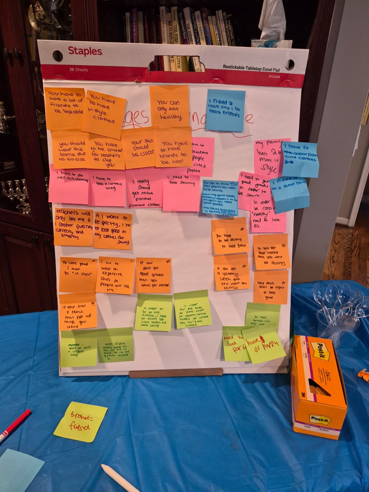 Sticky notes covering a whiteboard with messages about social pressure written by club members